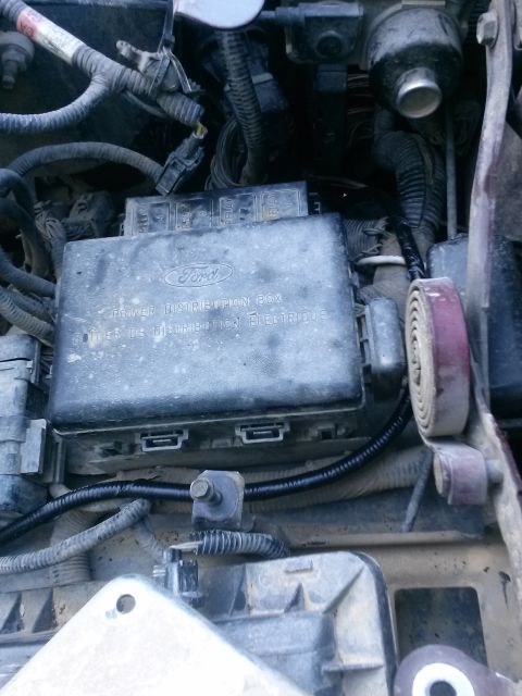 1996 Ford Bronco - The image shows a close-up view of a Ford power distribution box under the hood of a vehicle. The box has text that reads "POWER DISTRIBUTI…