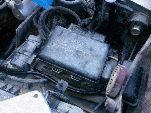 1996 Ford Bronco - A close-up view of the engine bay of a 1996 Ford Bronco, focusing on the power distribution box and various wiring harnesses.