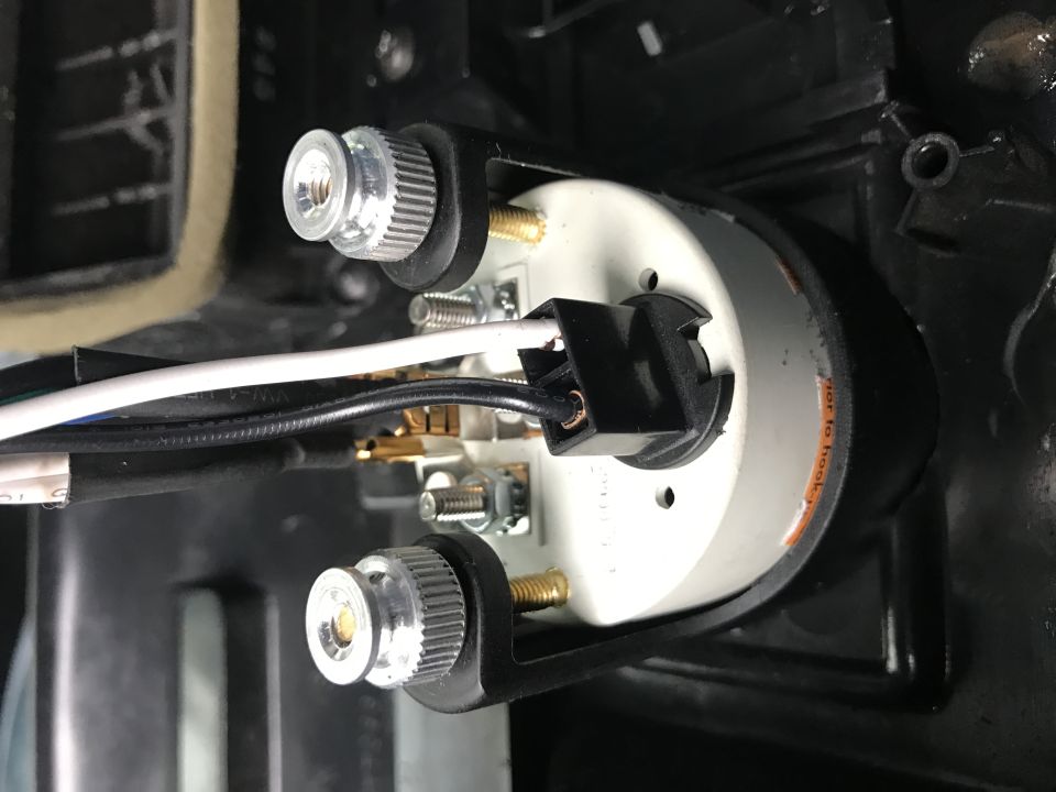 Rear view of a gauge with wires and mounting hardware.