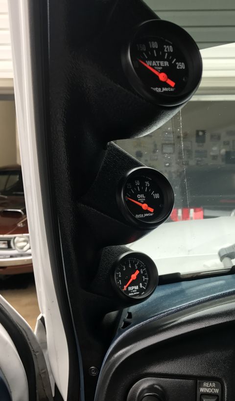 1995 Ford Bronco - A black dashboard mount holds three Auto Meter gauges: a water temperature gauge, an oil pressure gauge, and a tachometer. The gauges are a…