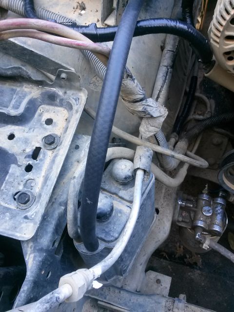 1996 Ford Bronco - A close-up view of engine components in a 1996 Ford Bronco, showing various hoses, wires, and mechanical parts.