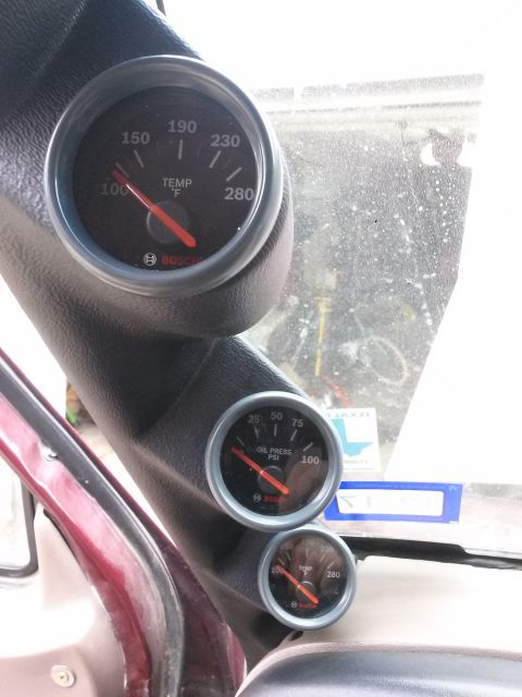1996 Ford Bronco - The interior of a vehicle shows a gauge cluster mounted on the A-pillar, featuring a temperature gauge and an oil pressure gauge. Both gaug…