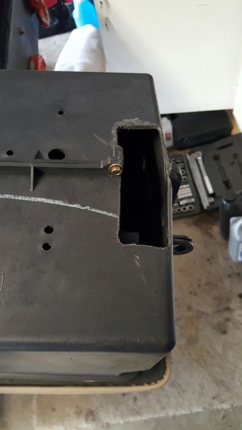 1996 Ford Bronco - A close-up view of a modified black plastic component, likely part of an air intake or battery box, with a rectangular section cut out. A g…