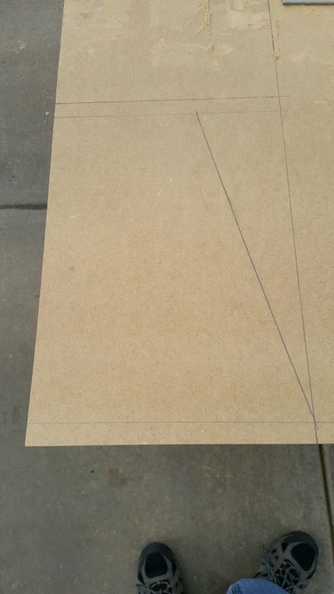1996 Ford Bronco - A close-up view of a piece of particle board with pencil lines drawn on it, indicating measurements or cuts. The board is resting on a conc…