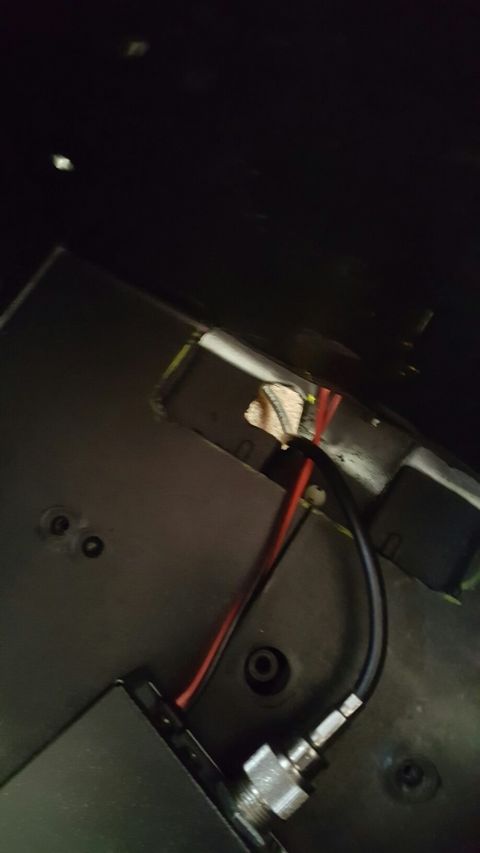1996 Ford Bronco - A close-up view shows red and black wires running through a cut-out in a black panel, with a silver connector visible in the lower right co…