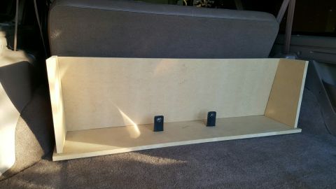1996 Ford Bronco - A custom-built wooden enclosure is placed on the carpeted floor of the rear cargo area of an SUV, likely a 1996 Ford Bronco. The enclosure…