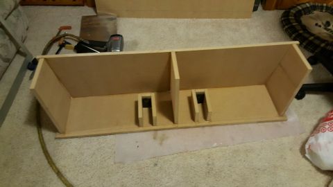 1996 Ford Bronco - A wooden enclosure with two compartments is shown on a carpeted floor. Tools, including a nail gun and clamps, are visible on the left side…