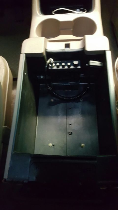 1996 Ford Bronco - This is an interior shot of a vehicle's center console, showing an open storage compartment with a CB radio mounted inside. The compartment…