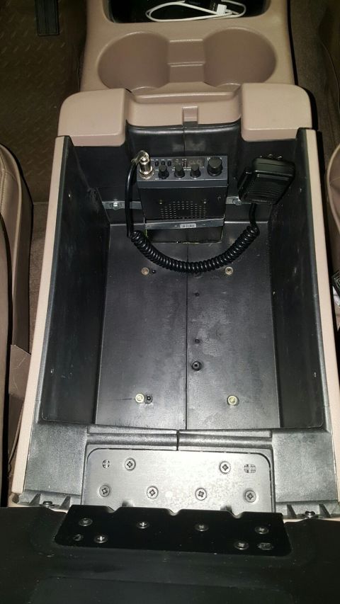 1996 Ford Bronco - An interior view of a vehicle's center console shows a CB radio and microphone mounted inside the storage compartment. The compartment is o…
