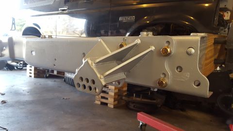 1994 Ford Bronco - A custom-fabricated, silver-painted steel bumper bracket assembly is attached to the frame of a black Ford Bronco. The bracket features mul…