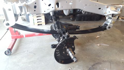 1994 Ford Bronco - A partially assembled vehicle chassis with a leaf spring suspension system and front axle assembly is shown. The frame and suspension compo…