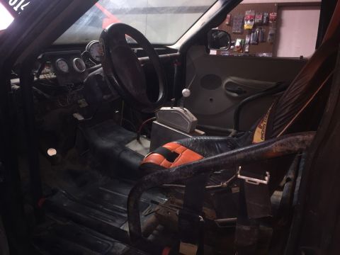 1982 Ford Bronco - The interior of a modified vehicle, likely a race car or off-road build, is shown from the passenger side. Visible elements include a roll…