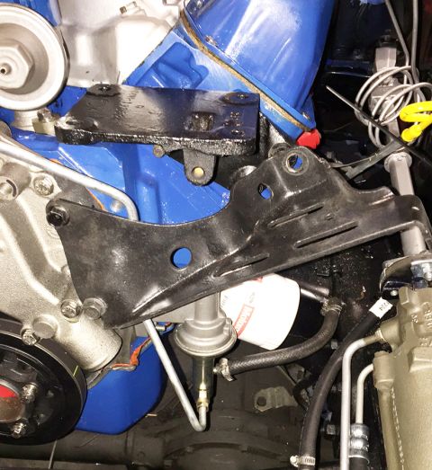 1978 Ford Bronco - A close-up view of a Ford V8 engine, featuring blue painted valve covers and a black metal bracket supporting a fuel filter and fuel pump.