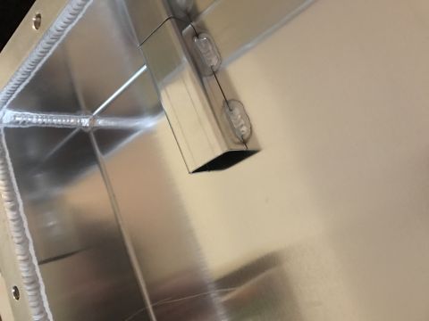 1995 Ford Bronco - A close-up view shows the interior of a custom aluminum fabrication, likely a fuel tank or oil pan, with visible welds and a small, angled…