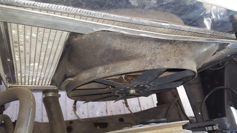 Underside view of a vehicle radiator and fan assembly.