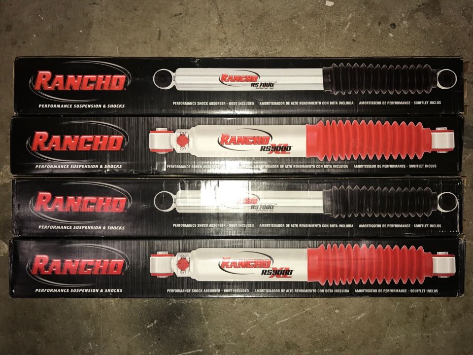 Four stacked boxes of Rancho RS7000 and RS9000 performance suspension and shocks.