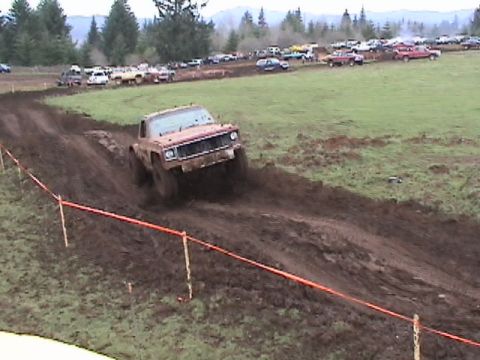 1994 Ford Explorer - A truck navigates a challenging mud course during an off-road event.