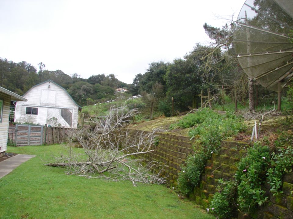 White barn and retaining wall with satellite dish