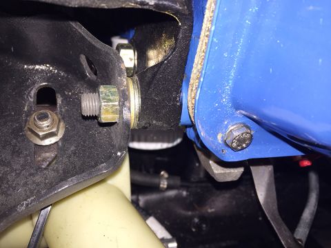 1978 Ford Bronco - A close-up view shows a bolted connection between a black metal bracket and a blue painted component, likely part of a vehicle's engine bay…