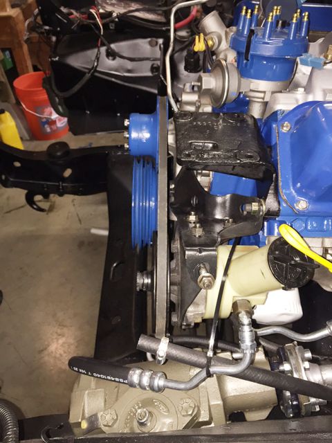 1978 Ford Bronco - A close-up view of a blue and black engine assembly, likely from a classic Ford, mounted in a vehicle frame. Visible components include the…