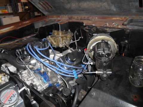 1972 Ford Bronco - The engine bay of a 1972 Ford Bronco shows a V8 engine with a carburetor, distributor, and blue spark plug wires. A brake booster and maste…