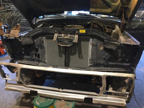 1979 Ford Bronco - The front end of a vintage Ford truck or SUV is shown with the hood open, revealing the engine bay and radiator. The front bumper and grill…