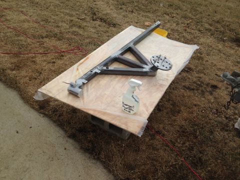1979 Ford Bronco - A metal frame structure is laid out on a wooden board outdoors. A spray bottle labeled "Danger! Muriatic Acid" is visible next to the frame.