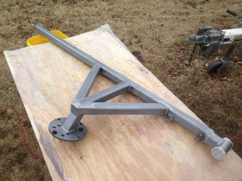 1979 Ford Bronco - A silver metal fabrication, possibly a trailer hitch or support structure, rests on a wooden surface outdoors. A yellow bucket and a traile…
