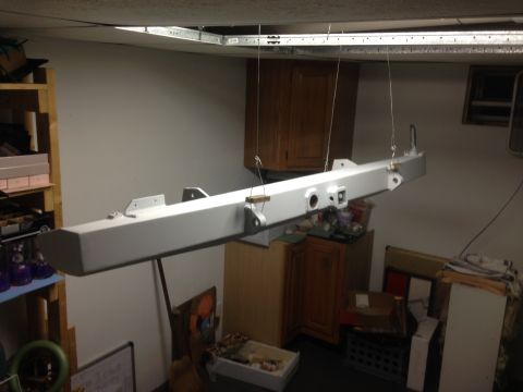 1979 Ford Bronco - A large, white, rectangular metal component, possibly a bumper or frame section, is suspended by wires from a ceiling grid. It appears to b…