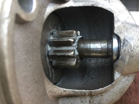 1979 Ford Bronco - A close-up view shows the splined shaft of a starter motor gear assembly, with some grease visible around the teeth and shaft.