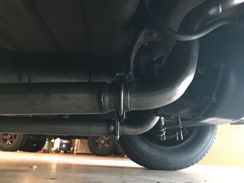 1965 Ford Mustang - The underside of a vehicle, showing the exhaust system and rear axle assembly. The vehicle appears to be a classic car, possibly a 1965 For…