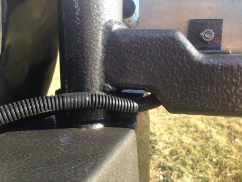 1979 Ford Bronco - A close-up view shows a black corrugated conduit running along a textured black metal frame, possibly part of a trailer hitch or chassis. A…