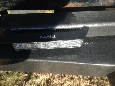 1979 Ford Bronco - A close-up view of a black LED light bar with the brand name "KAWELL" visible, mounted on a textured black surface, likely a vehicle bumper.