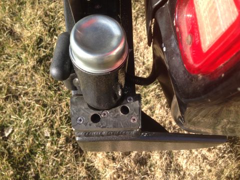 1979 Ford Bronco - A close-up view shows a black aftermarket trailer hitch receiver with a silver cap on a trailer hitch. The hitch is attached to the rear of…