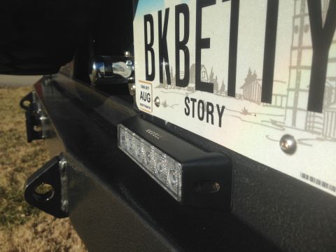 1979 Ford Bronco - A close-up view of the rear bumper and license plate of a vehicle. A black LED light bar is mounted below the license plate, which reads "B…