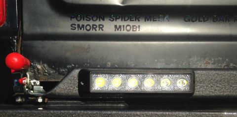 1979 Ford Bronco - A close-up view of the rear of a vehicle shows a black textured bumper with a row of six LED lights. Text is visible on the bumper above th…