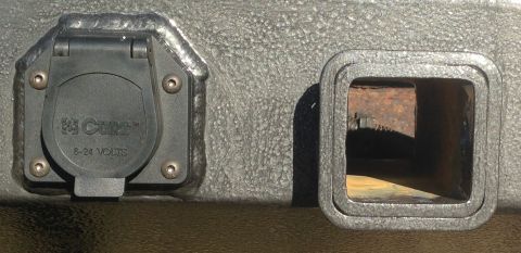 1979 Ford Bronco - A close-up view shows a CURT brand 6-24 VOLTS electrical connector and a 2-inch trailer hitch receiver opening, both mounted on a textured…