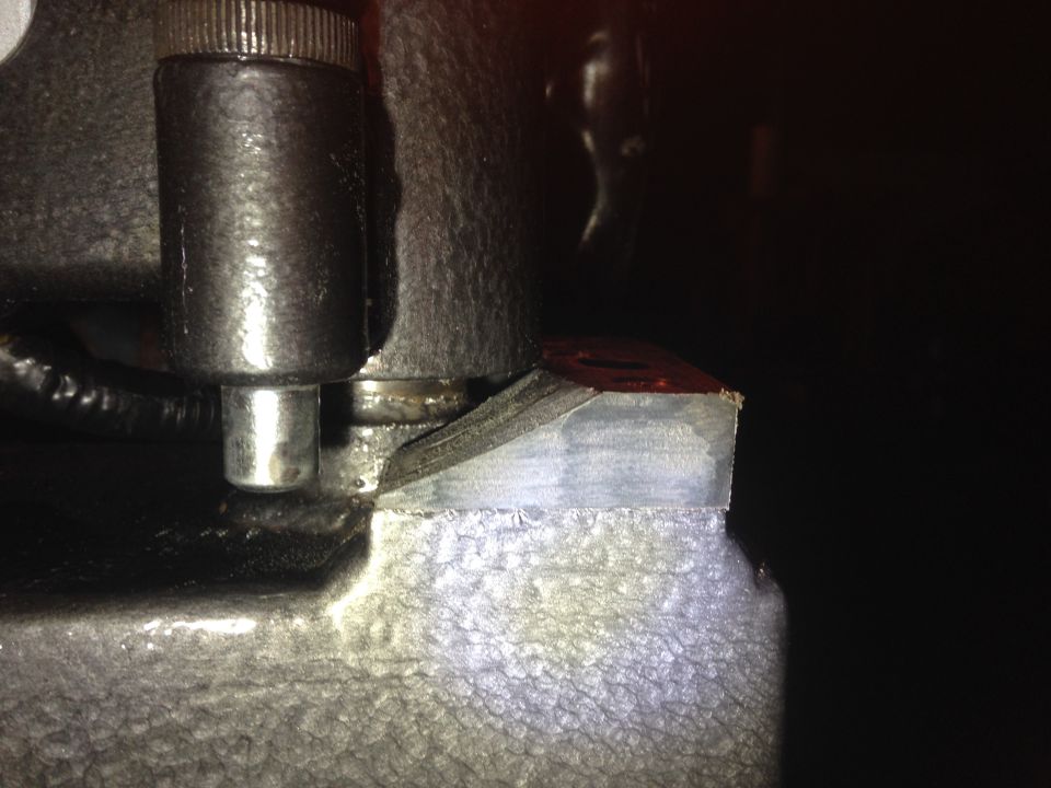 Close-up of a metal part with a bolt and textured surface