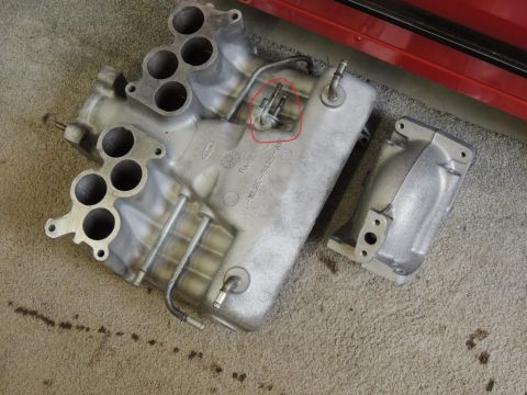 1974 Ford Bronco - A Ford intake manifold is shown, with a separate piece nearby and a red circle highlighting a connection point.
