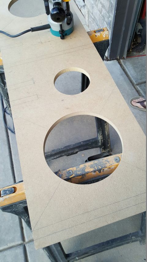 1996 Ford Bronco - A router is used to cut holes in a piece of MDF board, likely for speaker installation.
