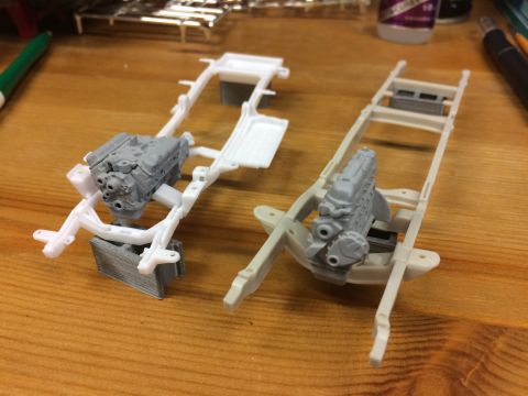 1989 Ford Bronco - Model car chassis and engines are laid out on a wooden workbench, ready for assembly.