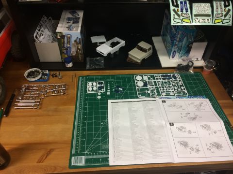 1989 Ford Bronco - Model car assembly in progress, with parts, instructions, and decals spread across a workbench.