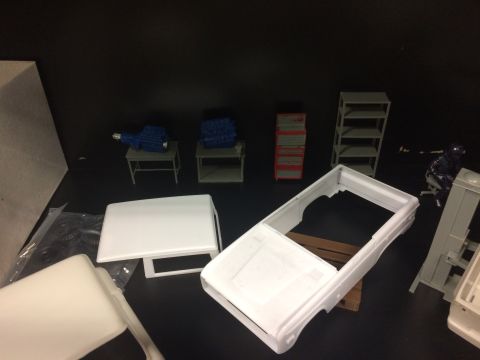 1989 Ford Bronco - Model car parts and engines are laid out on a dark surface, possibly for assembly.