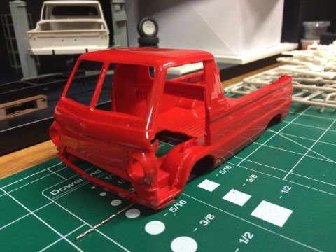 1989 Ford Bronco - A partially assembled red model truck body sits on a cutting mat, with other model parts in the background.