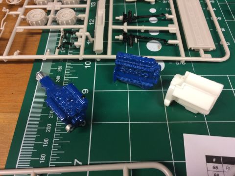 1989 Ford Bronco - Model engine parts and unassembled kit pieces are laid out on a cutting mat.