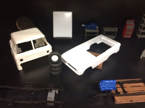 1989 Ford Bronco - Model car parts laid out on a dark surface, including a Bronco body and engine.