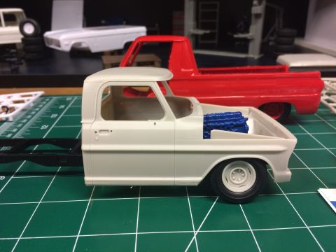 1989 Ford Bronco - Model truck parts, including a cab and engine, are laid out on a cutting mat.