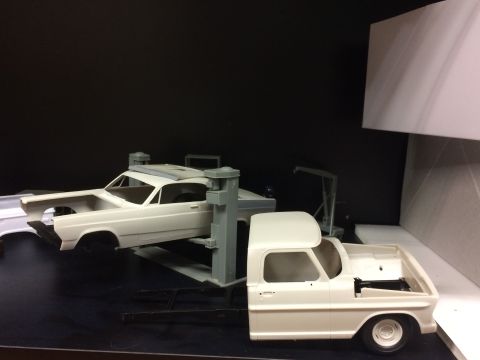1989 Ford Bronco - Two unpainted model car kits are displayed on a shelf. In the foreground is a pickup truck cab and chassis, and in the background is a car…