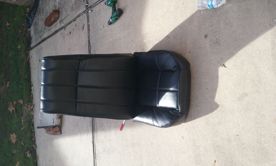 Black vinyl seat on concrete with drill and water bottle.