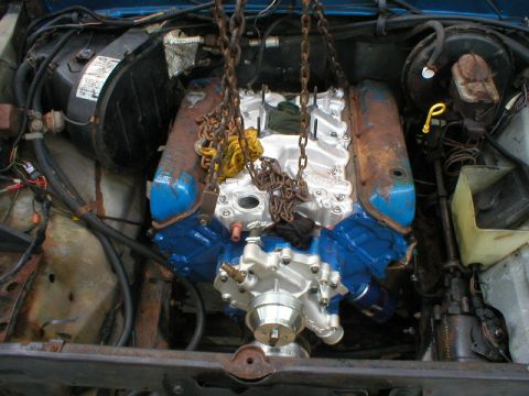 1978 Ford Bronco - Engine installation in progress, showing the engine suspended by chains within the vehicle's engine bay.